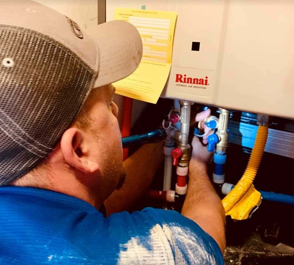 Travis doing repair work on a water heater